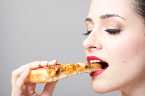 Девушка ест пиццу